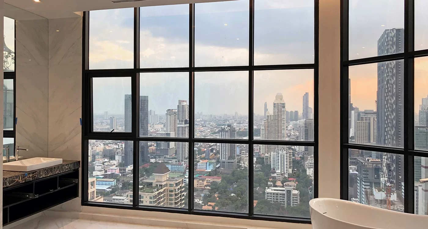 Bangkok skyline through large bathroom windows at Sathorn Gardens